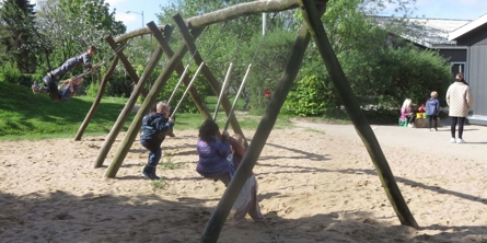 Børn gynger på gyngerne